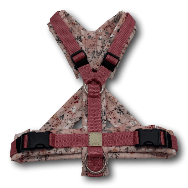 Y-förmiges Hundegeschirr auf schwarzem Hintergrund, mit blassrosa Polsterung und floralem Muster, rosa Gurtband und schwarzen Schnallen, Ede