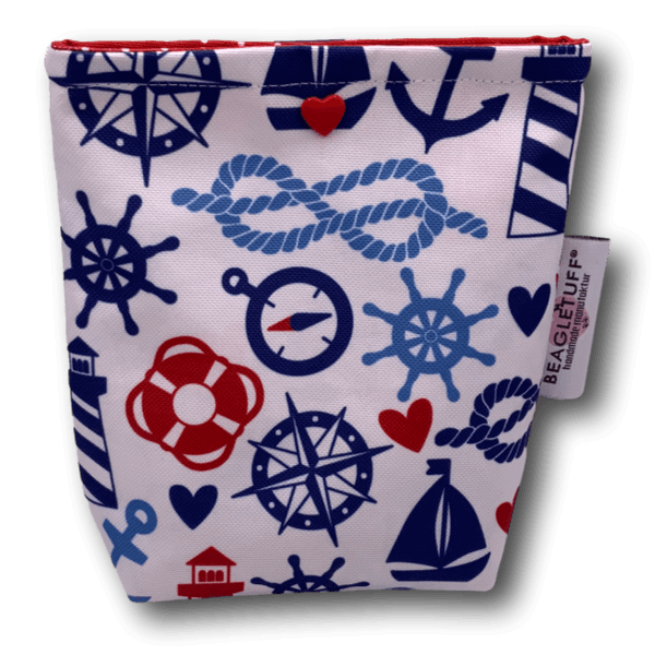 rechteckige Tasche aus Stoff mit maritimem Muster auf weißem Hintergrund, darauf sind Anker, Steuerräder, Rettungsringe, Kompasse, Segelboot