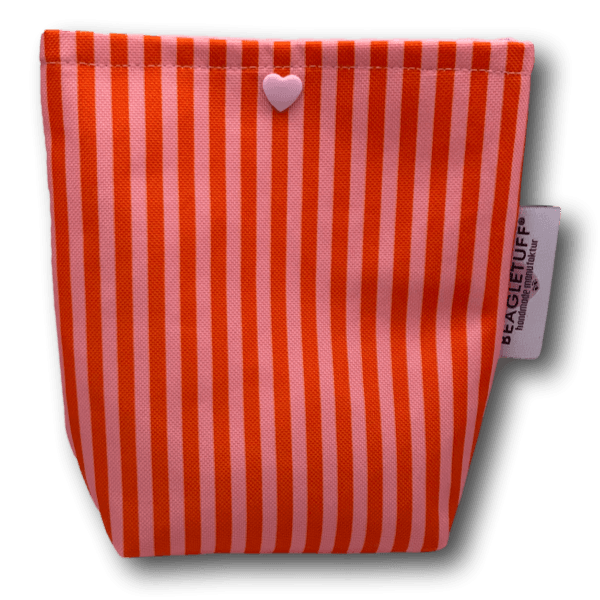 Tasche mit vertikalen Streifen in Orange und Rosa, vorne mittig ein kleines Herz aus Kunststoff in Rosa, rechts ein Label mit der Aufschrift