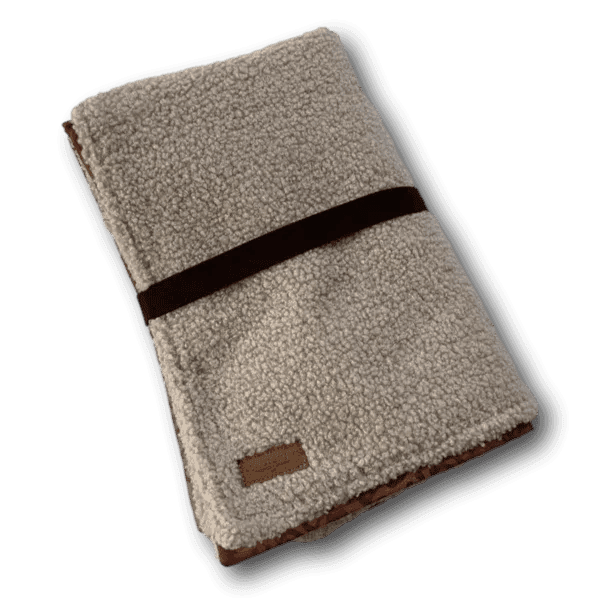 Beige-graue Hundedecke mit weicher, lockiger Fleecestruktur, gefaltet und mit dunklem Band umwickelt, braunes Label unten sichtbar mit BT Sn
