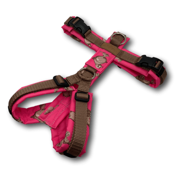 Y-förmiges Hundegeschirr in kräftigem Pink mit braunen, verstellbaren Gurtbändern und dekorativem Muster aus kleinen Tiermotiven. Das ergono