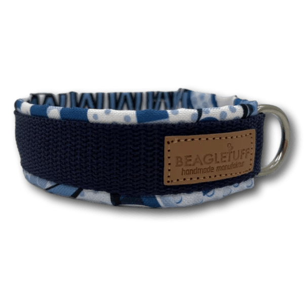 Blaues Hundehalsband mit gepolstertem Stoff in verschiedenen Blautönen und weißem Muster, mit braunem Lederpatch und silbernem Metallring mi